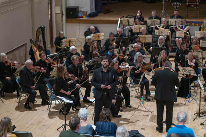 Baritone soloist Gareth Brynmor John performing in front of the orchestra